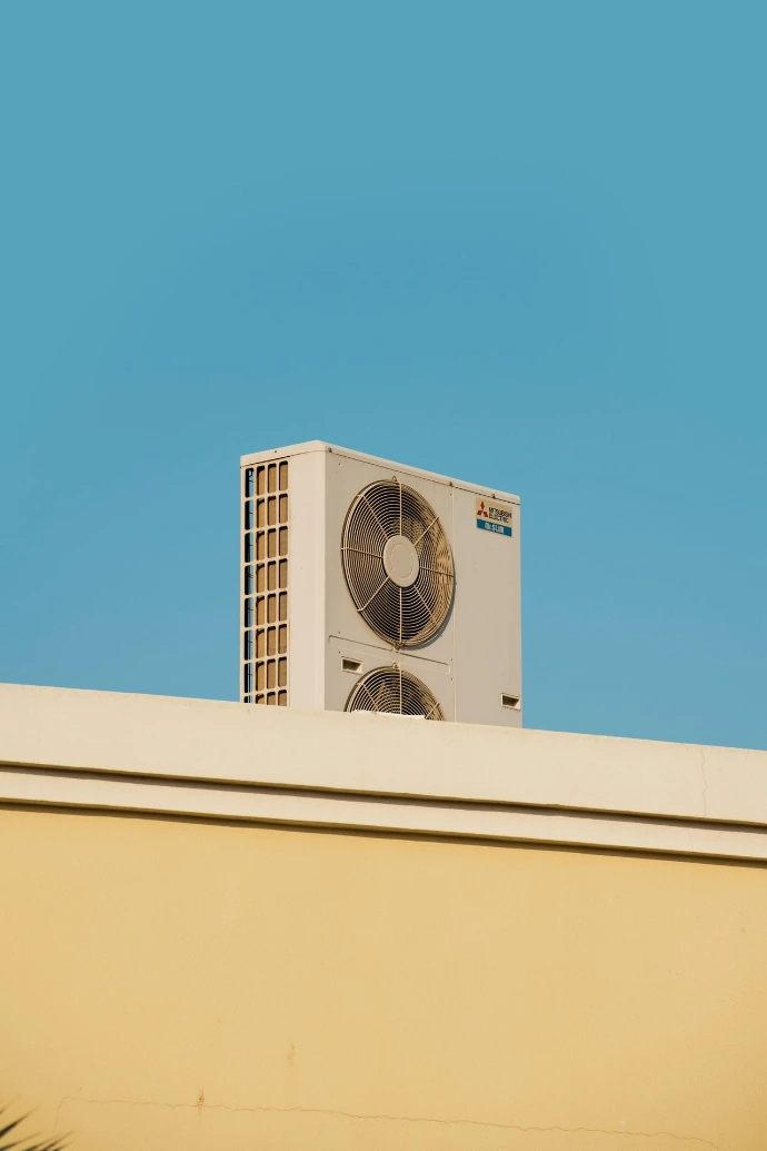 a white air conditioner sitting on top of a building